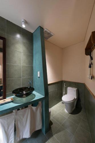 a bathroom with a sink and a toilet in it at HiuHill House in Cồn Giả Viên