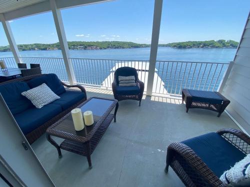 a balcony with couches and chairs and a view of the water at Lakeview Luxe Penthouse in Rocky Mount
