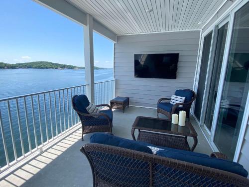 a balcony with chairs and a table and a tv at Lakeview Luxe Penthouse in Rocky Mount