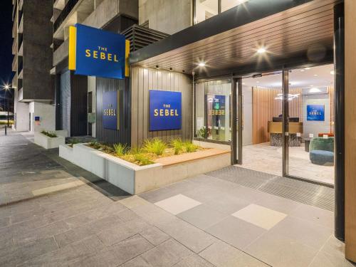 a store front with blue signs on the side of a building at The Sebel Canberra Campbell in Canberra