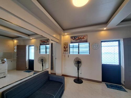 a living room with a couch and two fan at Seaview Transient House in Bucayao
