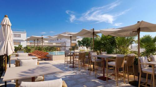 a patio with tables and chairs and umbrellas at Thompson Seville, by Hyatt in Seville