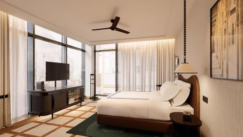 a bedroom with a white bed and a television at Thompson Seville, by Hyatt in Seville