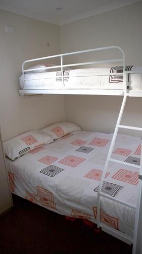 two bunk beds in a room with a bed at Iconic Luxury & Ocean Views in Apollo Bay