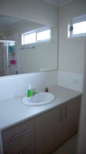 a bathroom with a white sink and a mirror at Iconic Luxury & Ocean Views in Apollo Bay
