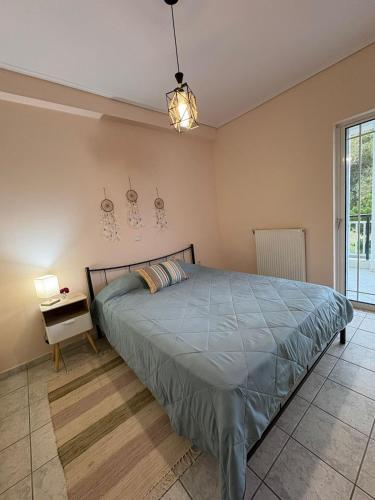 a bedroom with a bed and a table and a window at Seaside Apartment in Vrachati