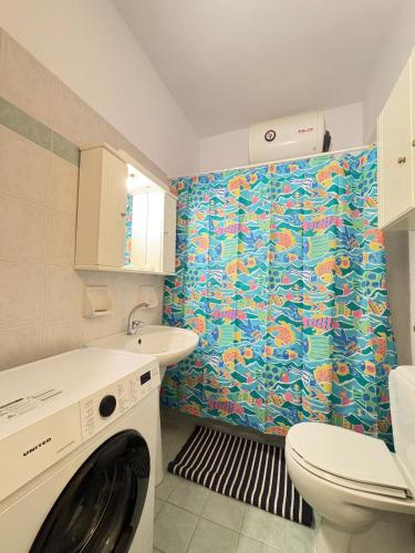 a bathroom with a washer and a sink and a toilet at Seaside Apartment in Vrachati