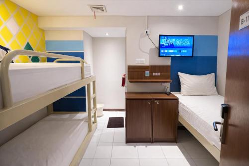 a room with two bunk beds and a tv at Subwow Hostel in Bandung