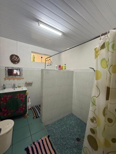 a bathroom with a shower curtain and a sink at Fare Holidays - Raiatea in Taputapuapea