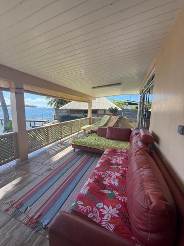 a living room with a couch on a balcony at Fare Holidays - Raiatea in Taputapuapea
