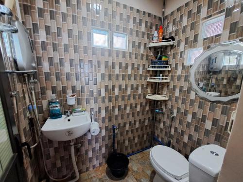 a small bathroom with a toilet and a sink at Seaview Transient House in Bucayao