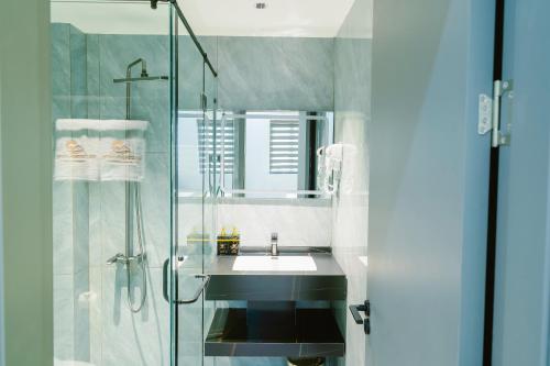 a bathroom with a sink and a glass shower at Tan Son Nhat Airport - Golden Sun Hotel in Ho Chi Minh City