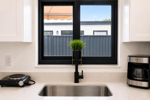 a kitchen sink with a plant in a window at MG Realty Luxury Stay in Miami