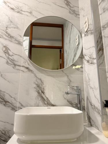 a bathroom with a white sink and a mirror at Departamento Ebenezer in Matarani