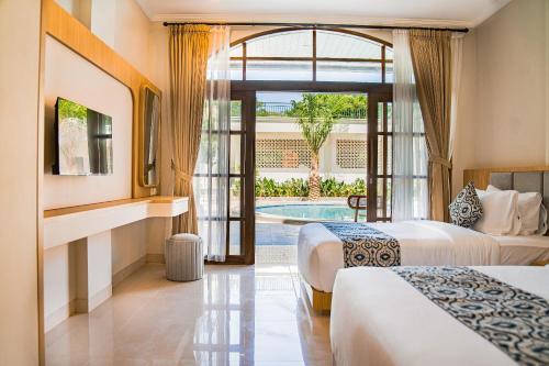 a hotel room with two beds and a pool at Sandat Mas Uluwatu in Uluwatu