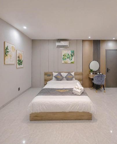 a bedroom with a large bed and a desk at Tan Son Nhat Airport - Golden Sun Hotel in Ho Chi Minh City