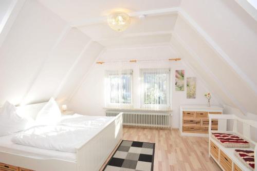 a white bedroom with a bed and a window at Haushaelfte-Kuddel-104 in Böhl