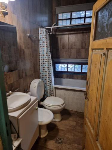 a bathroom with a toilet and a sink and a window at Mountain House with Wonderful View in Las Compuertas