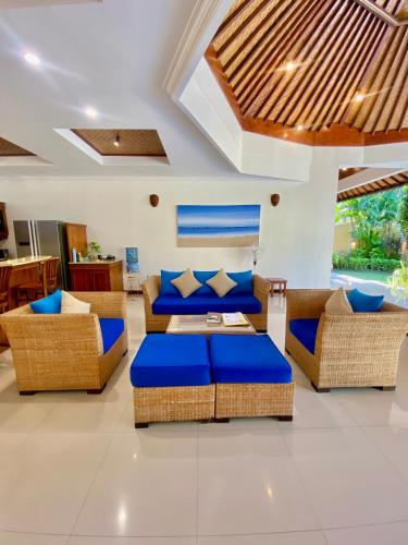 a living room with couches and blue pillows at Bali Emerald Villas in Sanur