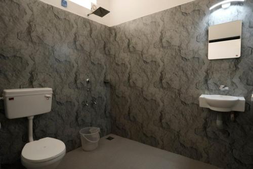 a bathroom with a toilet and a sink at Vagamon Hill Resort in Vagamon