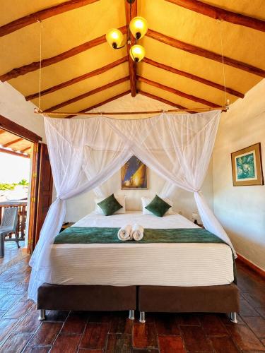 a bedroom with a canopy bed with two wedding rings at Posada Sueños de Antonio in Barichara