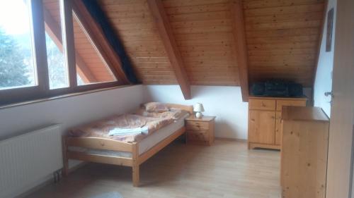 ein Schlafzimmer mit einem Bett in einem Holzhaus in der Unterkunft Apartment Lipno in Lipno nad Vltavou
