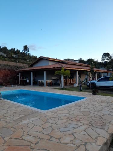 a swimming pool in front of a house at Recanto do Batata in Atibaia