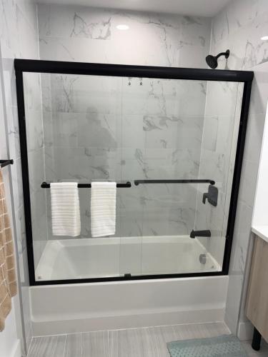 a glass shower in a bathroom with a tub at Coral Sands in Seaside Heights