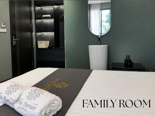 a bedroom with a bed with two towels on it at Olive SamSon Hotel in Sầm Sơn