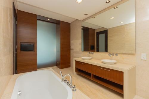 a bathroom with two sinks and a large mirror at Straits Quay Waterside Penang in Tanjong Tokong
