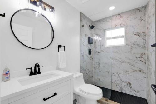 a bathroom with a sink and a toilet and a mirror at Ocean Retreat C in Boynton Beach