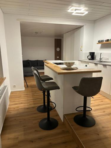 a kitchen with two chairs and an island in a room at bei gitta in Olpe