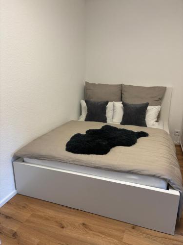a white bed with a black blanket on it at bei gitta in Olpe