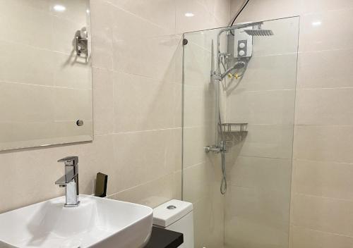 a bathroom with a shower and a sink and a toilet at Cris Inn - Bayugan in Bayugan City