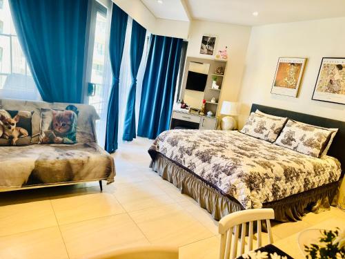 a bedroom with a bed and a couch at Carolina Peach, Studio unit E-6H Tambuli Resort! in Maribago
