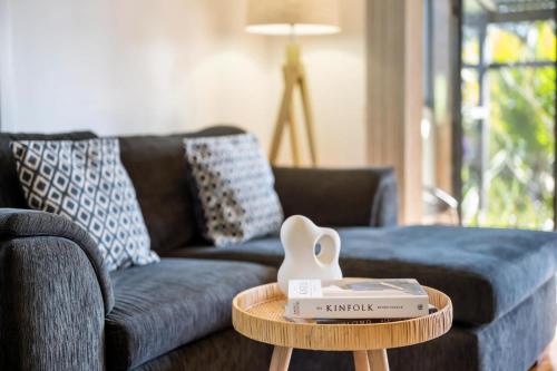 a living room with a blue couch and a table at Ma Te Kokorou - pet-friendly Huskisson pool escape in Huskisson