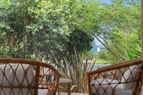 a patio with two chairs and a table and trees at Collingwood - 4BR modern beachfront holiday home in Vincentia