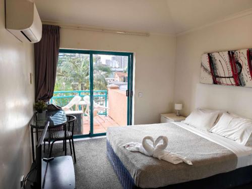 a hotel room with a bed with a towel on it at Aruba Surf Resort in Gold Coast