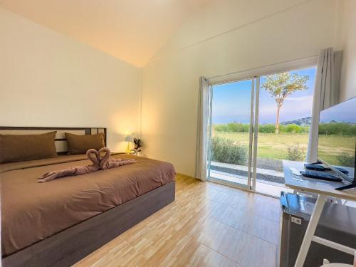 ein Schlafzimmer mit einem Bett und einem großen Fenster in der Unterkunft DOO KHAO in Ban Chong Tako