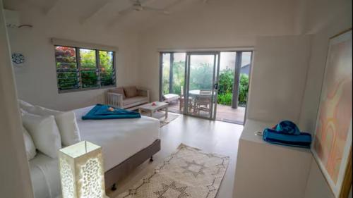 a white living room with a bed and a couch at Raitotoka Eco Resort in Matei