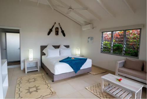 a bedroom with a bed with a blue umbrella on it at Raitotoka Eco Resort in Matei