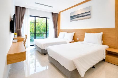 a hotel room with two beds and a window at COBI’s Home in Cam Lâm