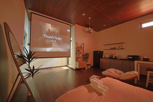 a large projection screen in a room with a kitchen at Àla Homestay Cần Thơ in Can Tho