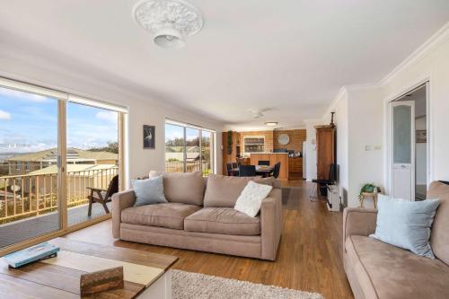 a living room with a couch and a table at Rennies Beach Escape "Carinya" in Ulladulla