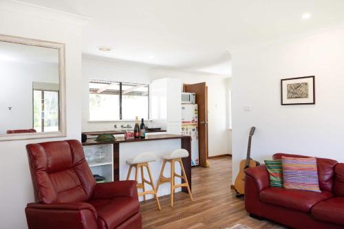 a living room with a couch and a kitchen at Sandy's Beach Shack at Bawley in Bawley Point