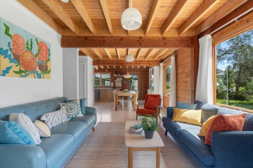 a living room with a blue couch and a table at The Beach Haven in Bawley Point