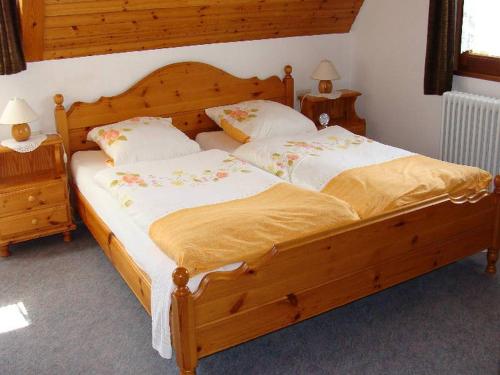 ein Schlafzimmer mit einem großen Holzbett mit zwei Kissen in der Unterkunft Ferienhaus im Grund in Hinterzarten