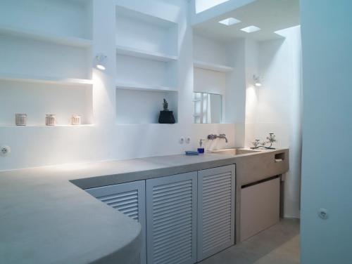 a white kitchen with a sink and a counter at Tutti Blu Tinos Living Space in Mési