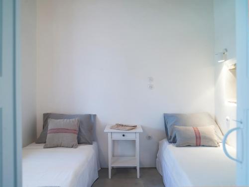 two beds sitting next to each other in a room at Tutti Blu Tinos Living Space in Mési
