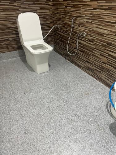 a bathroom with a toilet with a hose at Sari Highlands chopta Offbeat campsite in Ukhimath